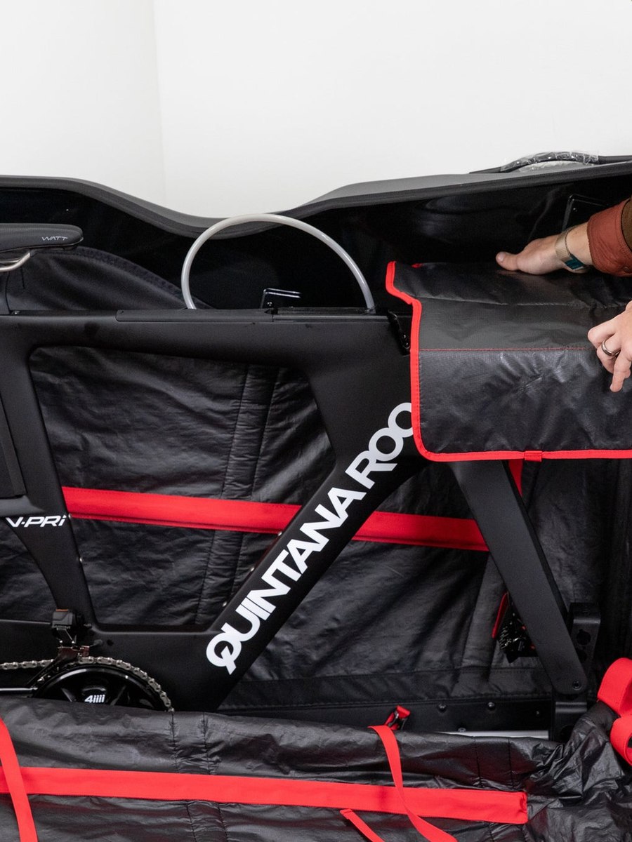A triathlon bike secured inside a padded travel bag, packed for the flight to Cozumel